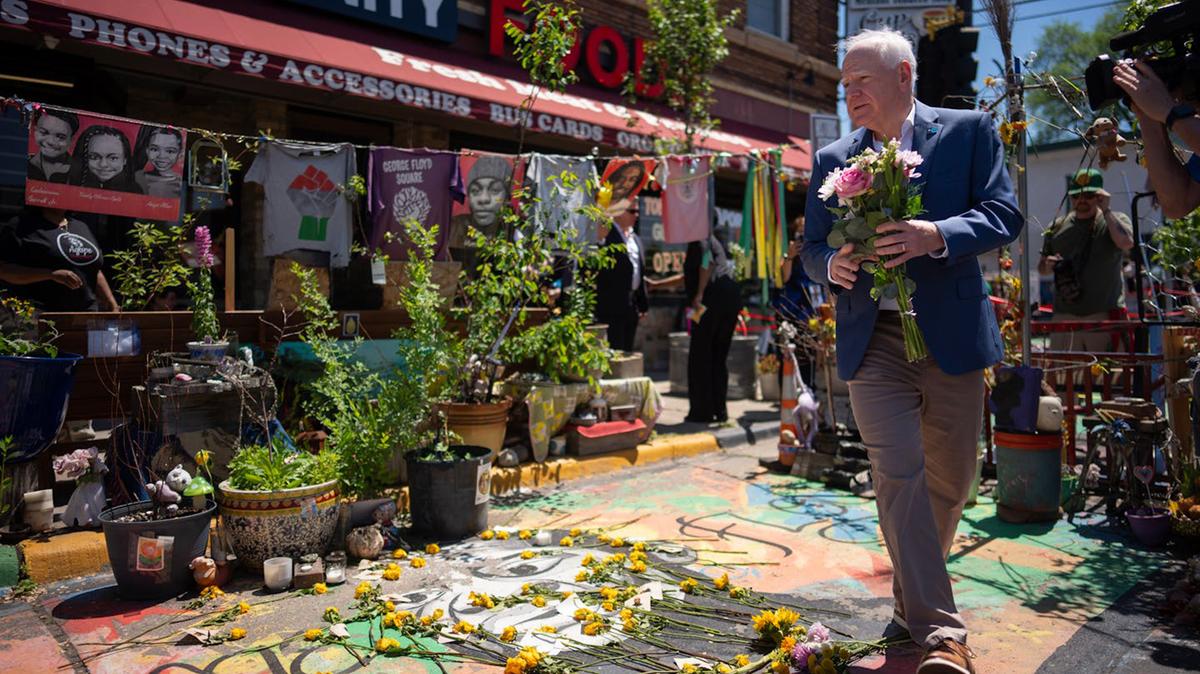 Minnesota Gov. Tim Walz carries a bouquet of flowers to leave at the memorial to George Floyd in George Floyd Square in Minneapolis on Monday, May 25, 2026, the anniversary of Floyd’s death. The site of Floyd’s 2020 killing by a Minneapolis police officer was host to the Rise and Remember Festival, with speakers, art, music, vendors and family activities centered on racial justice. (Jeff Wheeler/The Minnesota Star Tribune/TNS)
