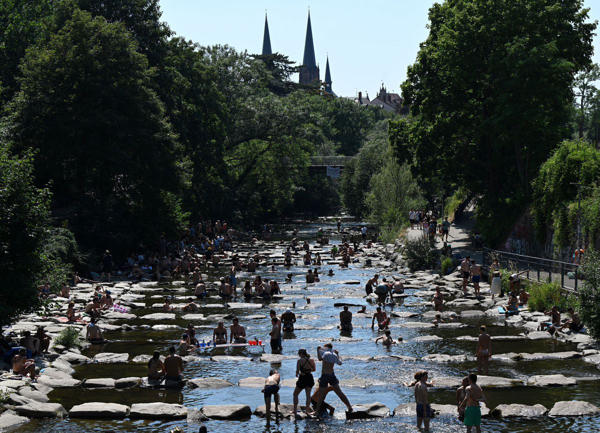 People enjoy the water of the Dreisam river at the so called water terraces in Freiburg, Germany, June 27, 2026, as temperatures in parts of the country are expected to raise to over a 40 C record high this weekend.   REUTERS/Anne Ackermann