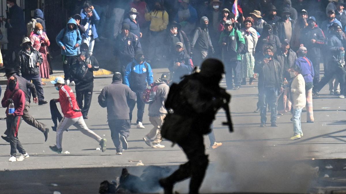 FILE PHOTO: A police officer runs in front of demonstrators during a march calling for the resignation of Bolivian President Rodrigo Paz, as the country’s economic and fuel crisis worsens due to a shortage of U.S. dollars and declining domestic energy production, in La Paz, Bolivia, May 25, 2026. REUTERS/Claudia Morales/ File Photo