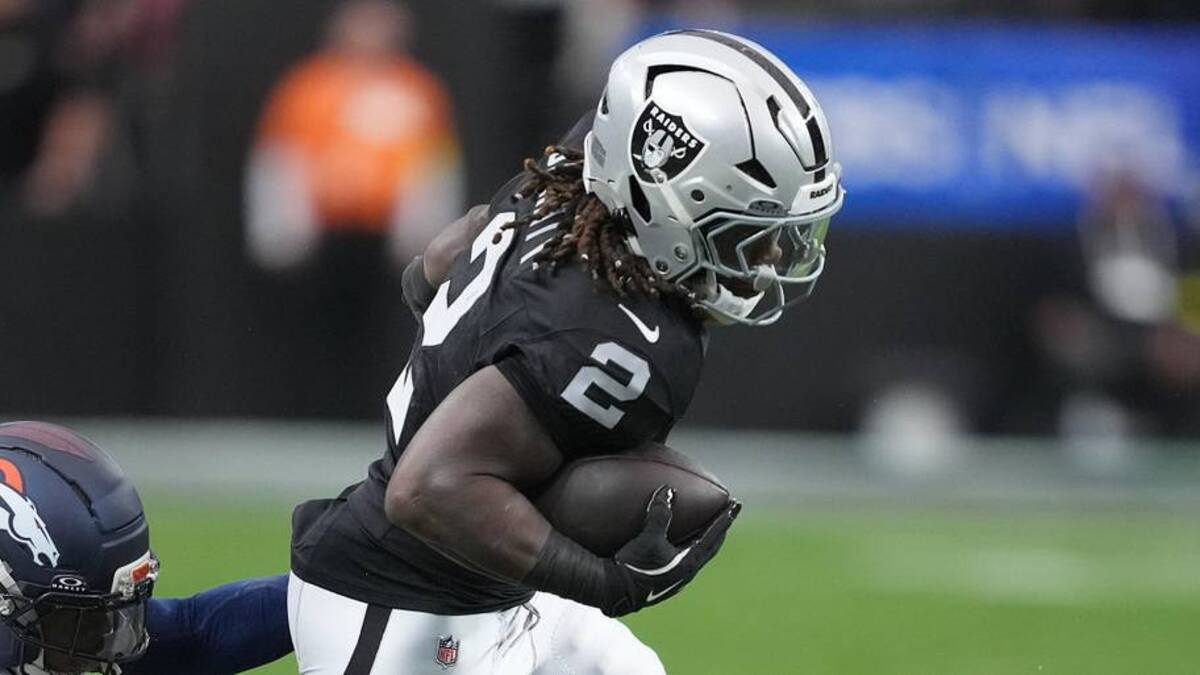  Dec 7, 2025; Paradise, Nevada, USA; Las Vegas Raiders running back Ashton Jeanty (2) carries the ball as Denver Broncos cornerback Jahdae Barron (23) defends during the first half at Allegiant Stadium. Mandatory Credit: Kirby Lee-Imagn Images | Kirby Lee-Imagn Images 