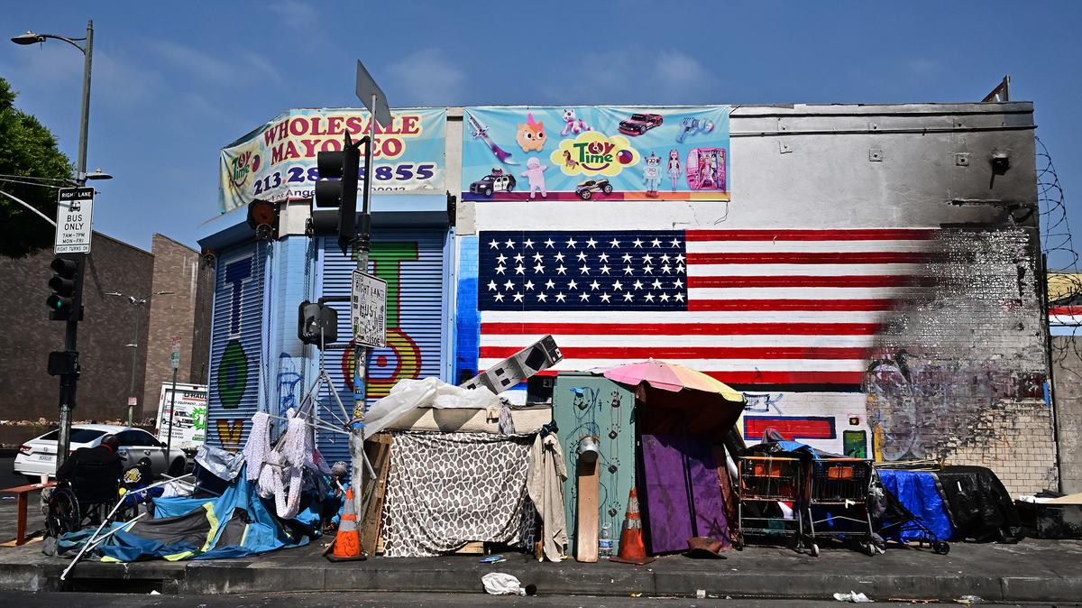 The flag of the United States is seen partially destroyed on a wall behind a homeless encampment in Los Angeles, California on Aug. 13, 2025, where ICE raids have sparked a summer of fear among immigrant communities with many people choosing not to be seen out on the streets. US President Donald Trump began his second term on Jan. 20 with a flurry of executive actions aimed at overhauling US immigration. His administration quickly moved to ramp up deportations, including by relaxing rules governing enforcement actions at "sensitive" locations such as schools, churches and workplaces. (Frederic J. Brown/AFP via Getty Images/TNS)