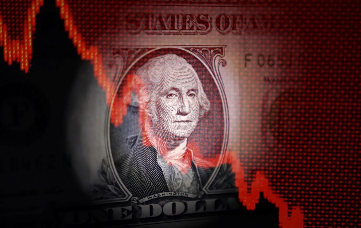 U.S. dollar banknote and decreasing stock graph are seen in this illustration taken April 25, 2025. REUTERS/Dado Ruvic/Illustration