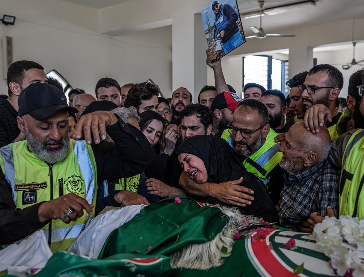 Mourners attend a funeral for photojournalist and paramedic Ahmad Hariri and two civil defense workers Ali Ghassani and Hussein Kassir in Tyre, Lebanon, Saturday, May 23, 2026. Dozens of Israeli airstrikes pounded Lebanon late Friday and early Saturday, killing and injuring several people, Lebanon's national news agency said, exposing the mounting strain on a truce between Israel and the Iran-backed Lebanese militant group Hezbollah. (Daniel Berehulak /The New York Times)