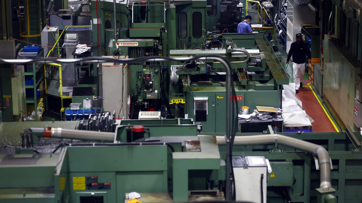 Workers walk between precision-machining machines for automotive parts inside a factory at Kyowa Industrial Co. in Takasaki, Gunma Prefecture, Japan April 11, 2025.  REUTERS/Issei Kato