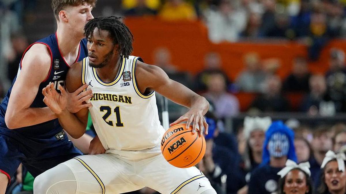  Apr 6, 2026; Indianapolis, IN, USA; Michigan Wolverines forward Morez Johnson Jr. (21) controls the ball against UConn Huskies center Eric Reibe (12) during the first half in the national championship of the Final Four of the men's 2026 NCAA Tournament between the and the Michigan Wolverines at Lucas Oil Stadium. Mandatory Credit: Bob Donnan-Imagn Images | Bob Donnan-Imagn Images 