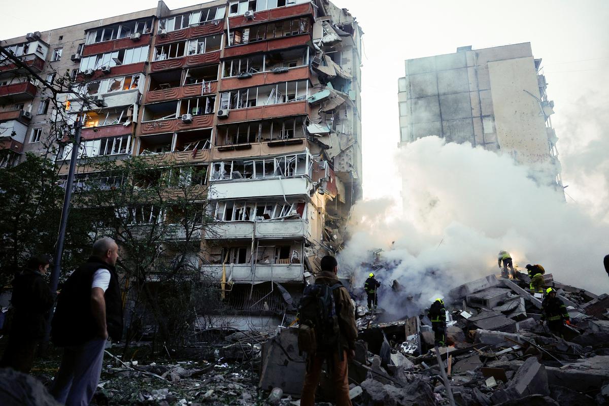 Residents look on as rescuers work at the site of an apartment building damaged during Russian missile and drone strikes, amid Russia's attack on Ukraine, in Kyiv, Ukraine May 14, 2026. REUTERS/Valentyn Ogirenko