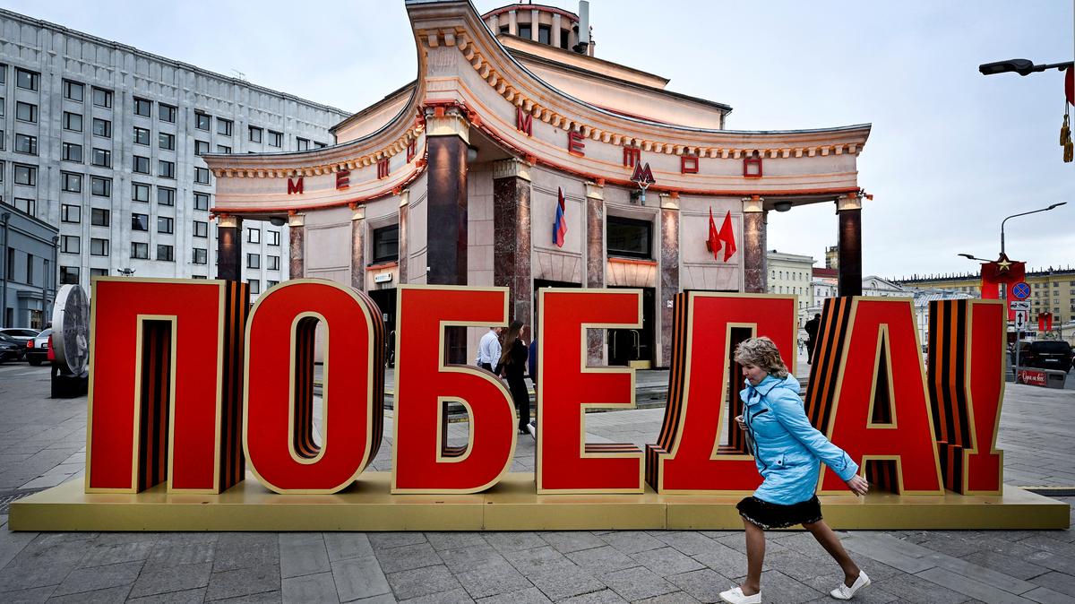 A woman runs past a V-day decoration reading "The Victory!" in front of a historical Arbatskaya metro station entrance (1935) in downtown Moscow on May 8, 2026, a day ahead of the Victory Day military parade, to be held at Red Square. Russia will celebrate the 81st anniversary of the 1945 victory over Nazi Germany on May 9. (Alexander Nemenov/AFP/Getty Images/TNS)