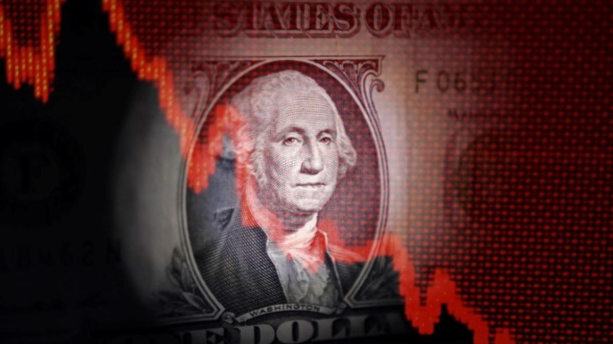 U.S. dollar banknote and decreasing stock graph are seen in this illustration taken April 25, 2025. REUTERS/Dado Ruvic/Illustration