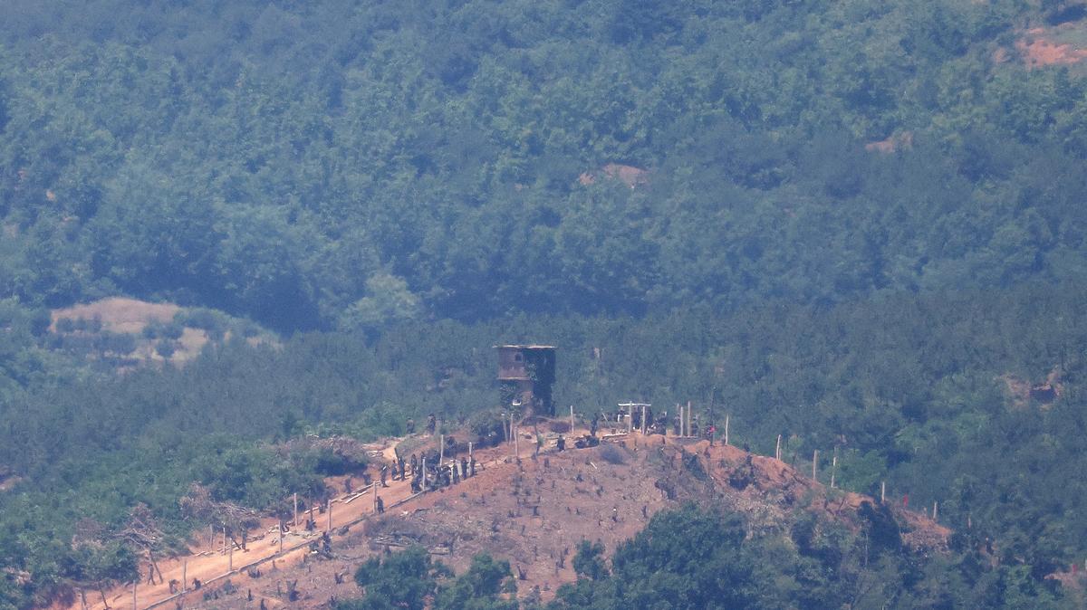 North Korean people work on a military fence near their guard post at the inter-Korean border in this picture taken from the observation deck near the demilitarized zone that separates the two Koreas in Paju, South Korea, June 4, 2024.    REUTERS/Kim Hong-Ji