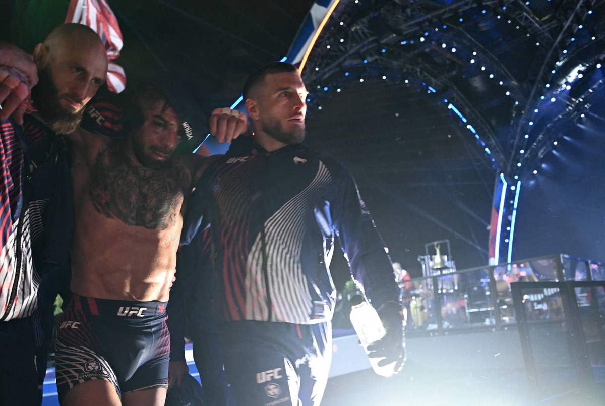  Aleksandre Topuria (R) assists his brother, Georgia's Ilia Topuria (C) Brendan SMIALOWSKI / AFP via Getty Images