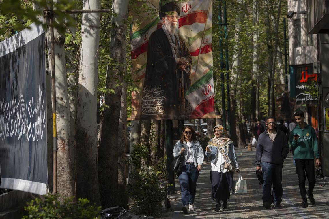 People walk under a banner of Ayatollah Ali Khamenei, who was killed in U.S.-Israeli airstrikes, in Tehran, on Thursday, April 16, 2026. President Donald Trump told reporters at the White House that the next in-person negotiations with Iran might occur this weekend. (Arash Khamooshi/The New York Times)