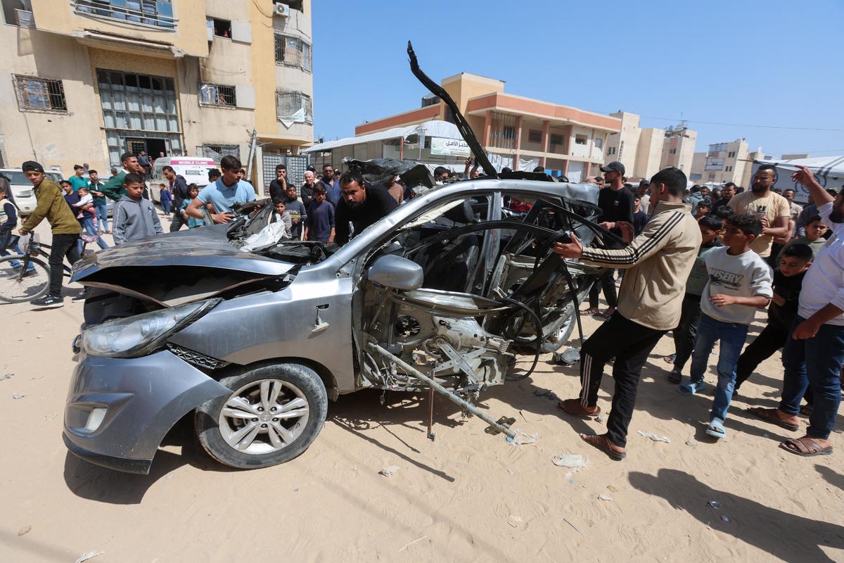 Palestinians inspect the site of an Israeli strike on a car in Khan Younis, in the southern Gaza Strip, May 10, 2026. REUTERS/Ramadan Abed