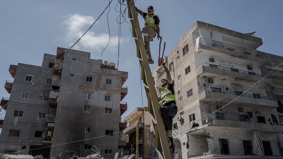 Civil defense workers cut fallen power lines as they clean up amid buildings destroyed in recent Israeli strikes in Tyre, Lebanon, May 29, 2026.