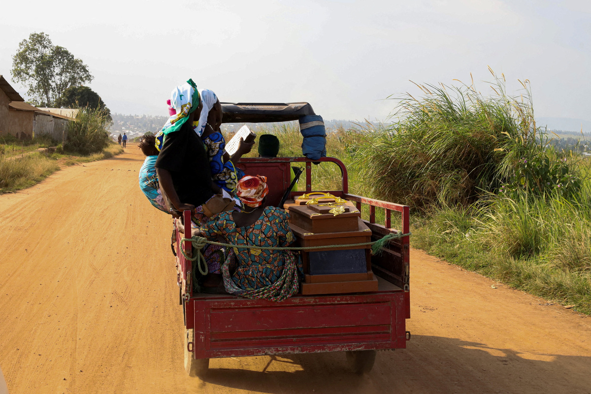 People of the Kigonze displaced persons camp sit on a tricycle next to the coffin of their relative who died from Ebola as they head for burial at Nyamurongo Cemetery, one month after an Ebola outbreak was declared, in Bunia, eastern Democratic Republic of Congo, June 18, 2026. REUTERS/Gradel Muyisa Mumbere
