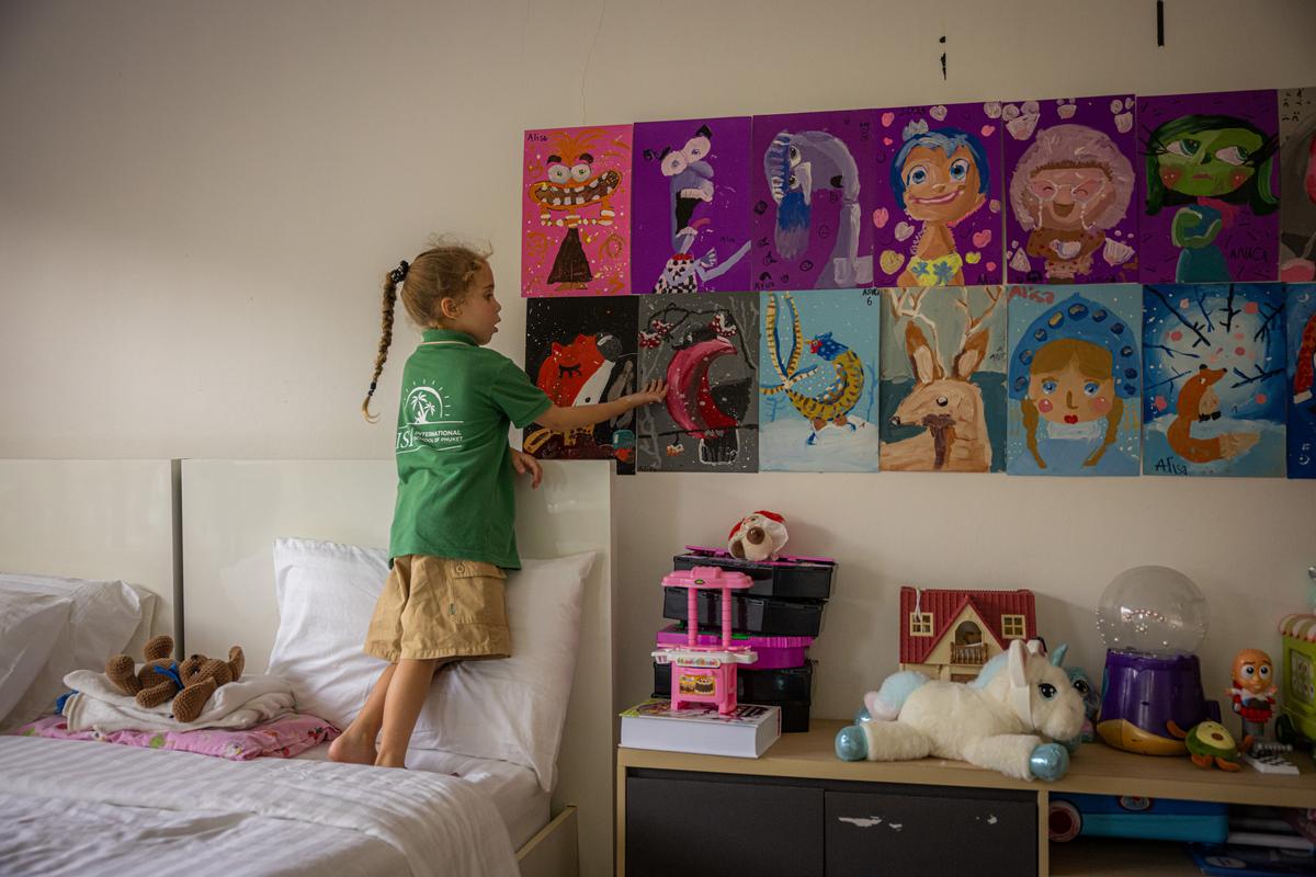 Alisa Mittsel, 6, whose family moved to Phuket after Russia invaded Ukraine, with her artwork at home in Rawai, Thailand on March 9, 2026. The Mittsels are among the hundreds of thousands of Russians who left the country after the 2022 invasion, with some 30,000 Russian émigrés now on Phuket. Many of them see it as calmer than Bali, cheaper than Dubai and friendlier than Europe. (Lauren DeCicca/The New York Times)..
