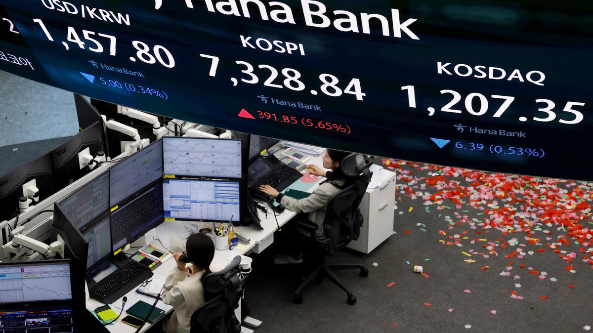 Currency dealers work as an electronic board displays the Korea Composite Stock Price Index (KOSPI), the exchange rate between the U.S. dollar and South Korean won and the Korea Securities Dealers Automated Quotations (KOSDAQ) at the dealing room of a bank, as the benchmark KOSPI index opened above the 7,000 mark in Seoul, South Korea, May 6, 2026. REUTERS/Kim Soo-hyeon