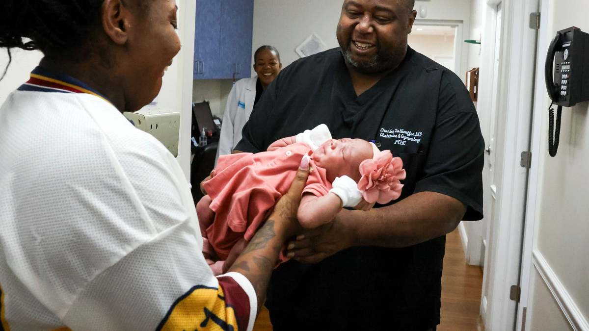 Alchrine Burke, of Port St. Lucie. introduces her 15-day-old daughter Kamayla to Dr. Charles Zollicoffer, an