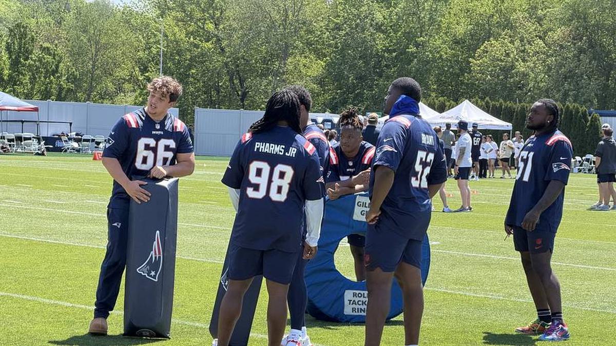  Members of the New England Patriots offensive and defensive line help set up a tackling drill. | Ethan Hurwitz / Patriots On SI 