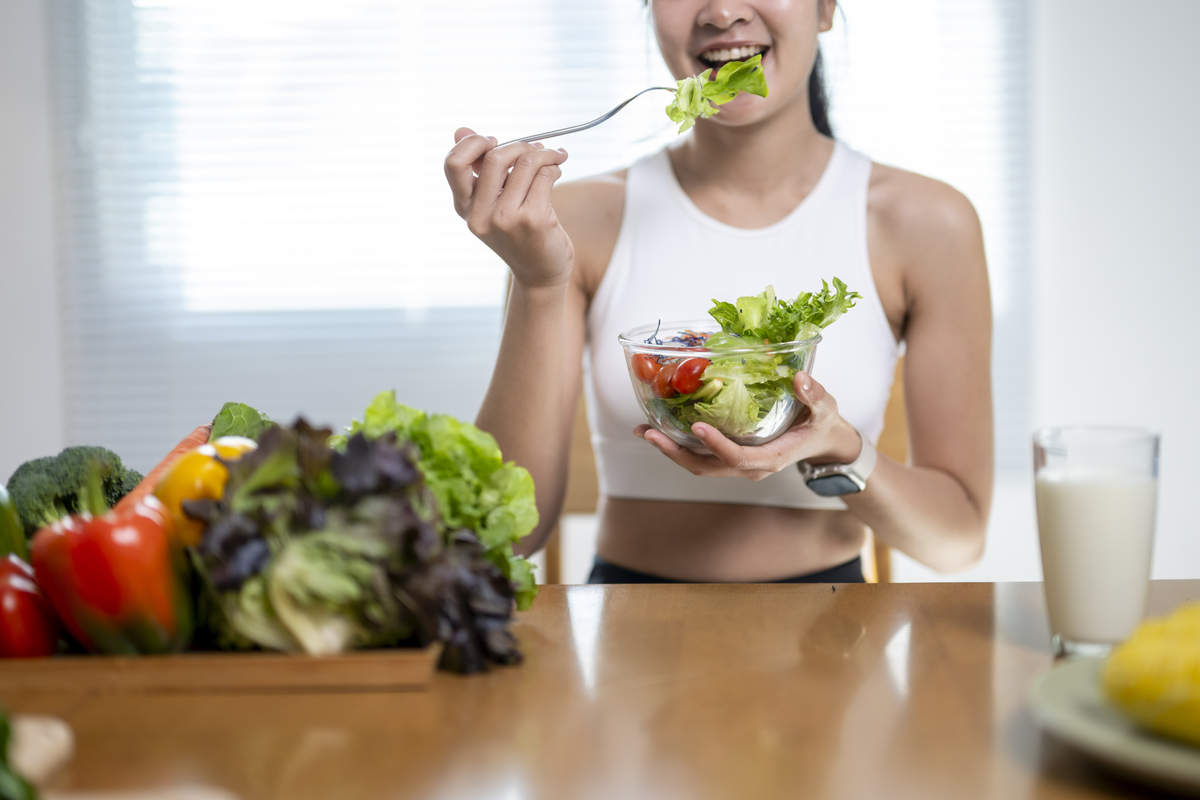  A stock image shows a young woman enjoying a fresh vegetable salad. 