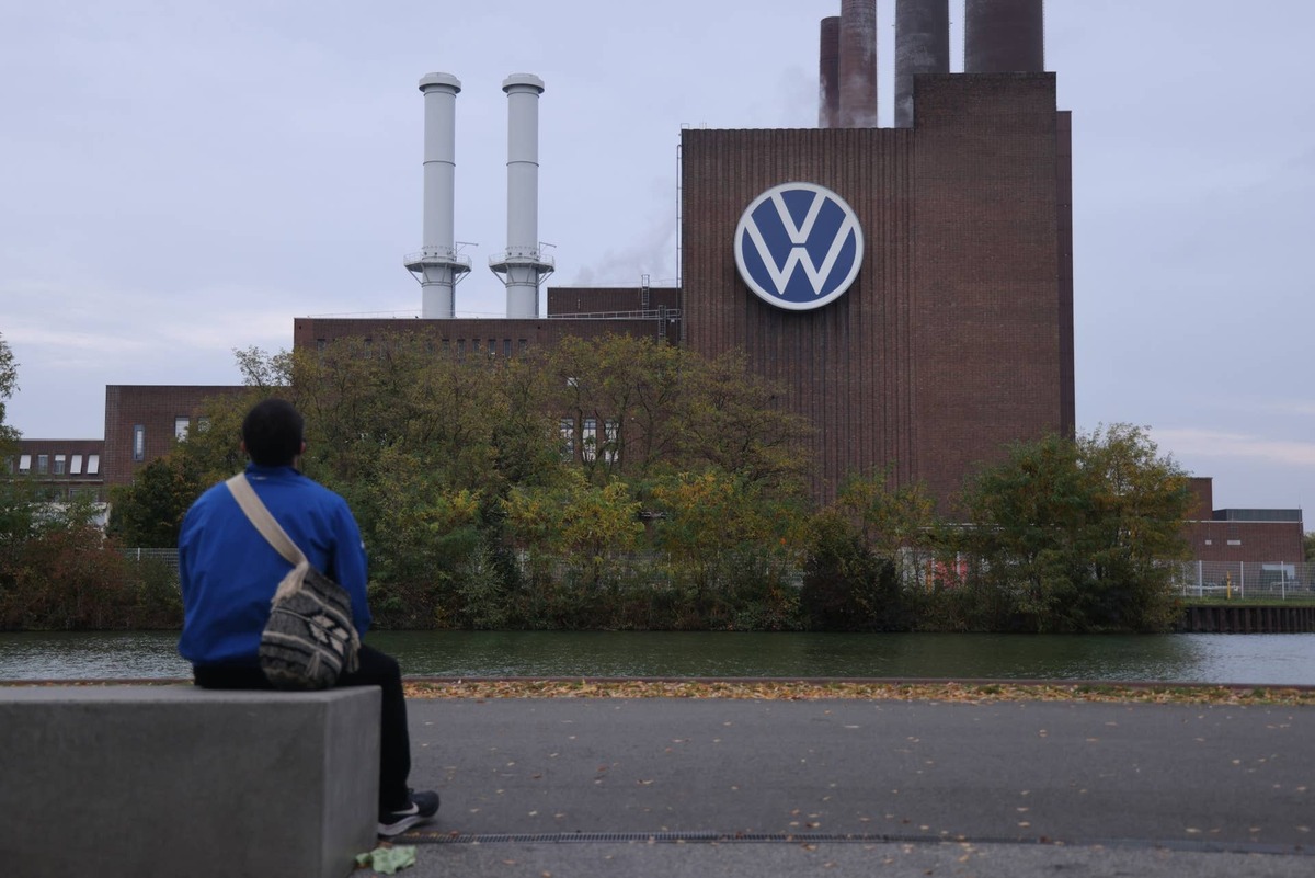 WOLFSBURG, GERMANY - OCTOBER 28: A man sits across from the Volkswagen factory on October 28, 2024 in Wolfsburg, Germany. The Volkswagen workers' council announced today that Volkswagen plans to shutter three of its ten German plants in an effort to cut costs. The company has seen a worldwide decline in sales of both its gasoline and electric-powered cars. (Photo by Sean Gallup/Getty Images)