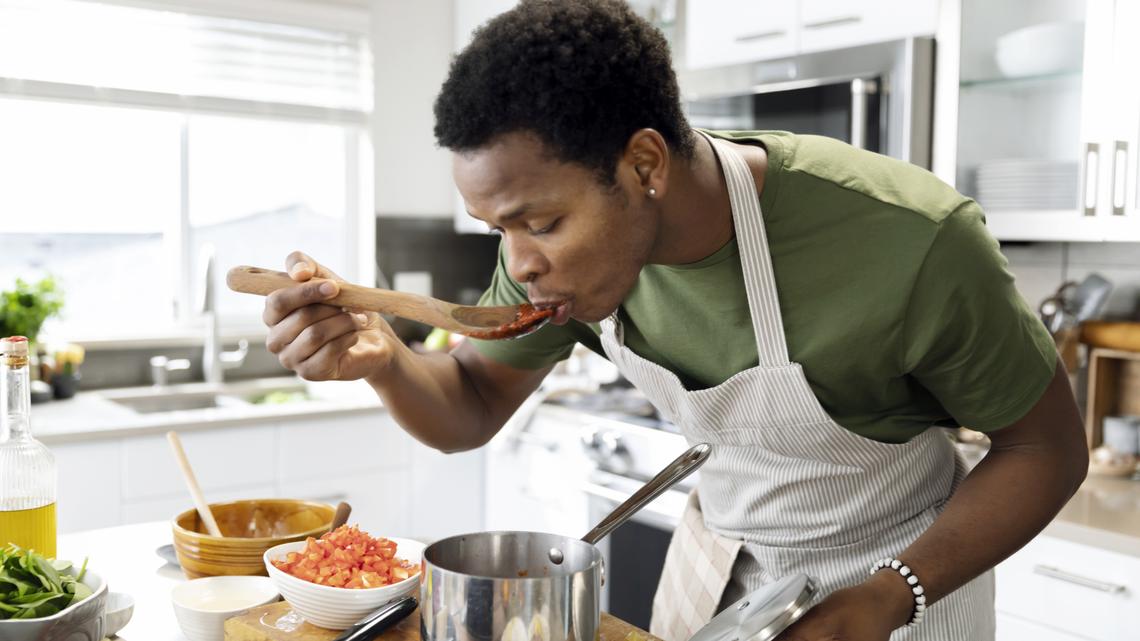 Man in his 20s tasting sauce, making lunch, enjoyment, healthy lifestyles, cooking