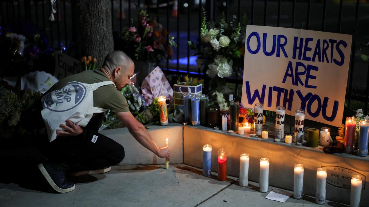 A man places a candle on the ground as he pays his respects in front of the Islamic Center of San Diego after the vigil in a park, the day after a fatal shooting incident, in San Diego, California, U.S., May 19, 2026. REUTERS/Daniel Cole