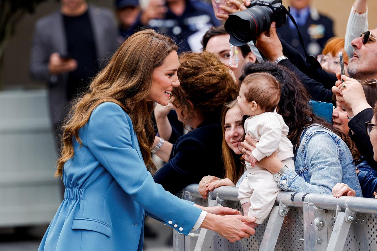 Britain's Catherine, Princess of Wales, interacts with a baby after visiting Reggio Emilia town hall during a two-day visit to the region, in Reggio Emilia, Italy, May 13, 2026. REUTERS/Remo Casilli