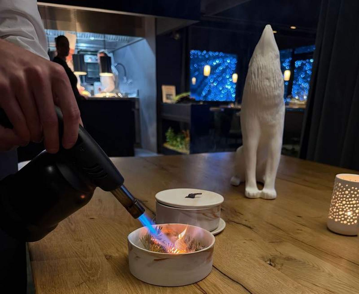  Dinner at Alpage inside Hotel Annapurna in Courchevel is a full sensory experience - here a server torches pine needles tableside, filling the room with the scent of the forest just outside. Photo credit: Liana Moore 