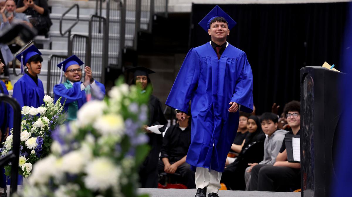 Mather High School senior Ricardo Hernandez-Navarrete flashes a smile as he walks on stage before receiving his diploma during his graduation ceremony at Loyola University Chicago on Thursday, May 28, 2026, in Chicago. Ricardo was detained by ICE in March and released this week just in time for graduation. (Chris Sweda/Chicago Tribune/TNS)