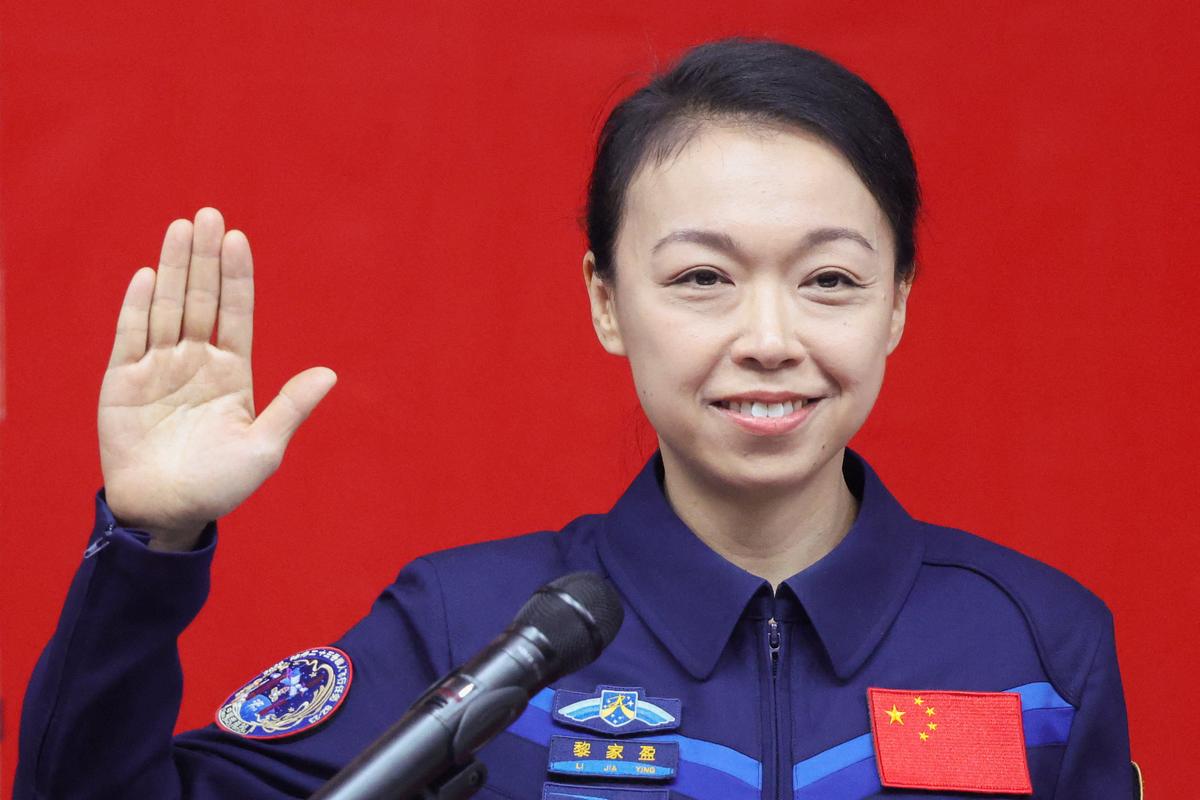 Astronaut Lai Ka-ying, who is the first astronaut from Hong Kong, raises her hand as she attends a press conference with fellow crew members Zhu Yangzhu and Zhang Zhiyuan (both not pictured), before the Shenzhou-23 spaceflight mission to China's Tiangong space station, at Jiuquan Satellite Launch Center, near Jiuquan, Gansu province, China, May 23, 2026. REUTERS/Maxim Shemetov