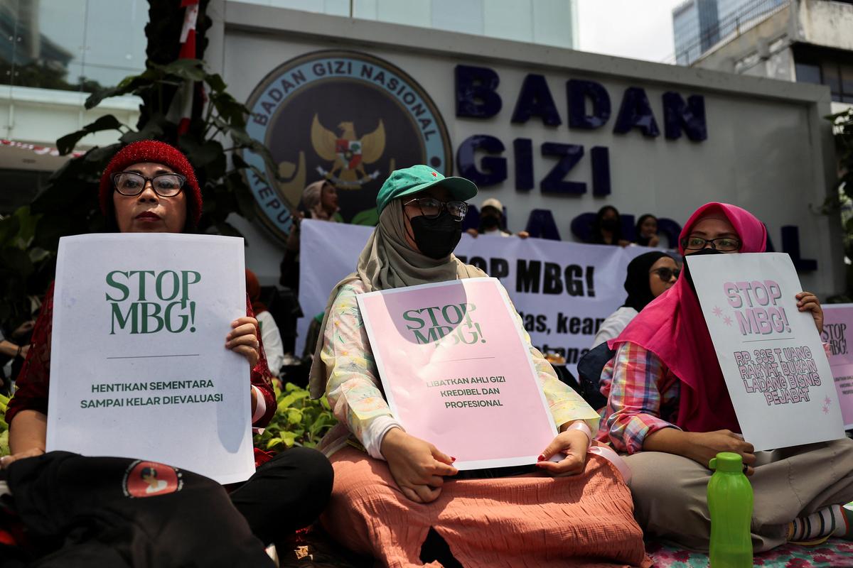 Protesters hold placards outside the National Nutrition Agency building during a rally demanding an end to the government's free nutritious meal (MBG) program, following cases of food poisoning in schools, in Jakarta, Indonesia, October 15, 2025. REUTERS/Willy Kurniawan