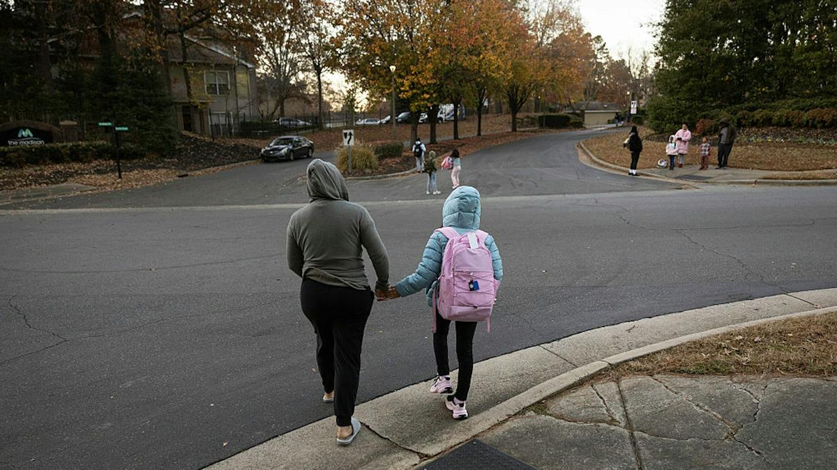 An undocumented Honduran immigrant walks her child to a school bus stop in November 2025 at an unspecified location in the U.S. 