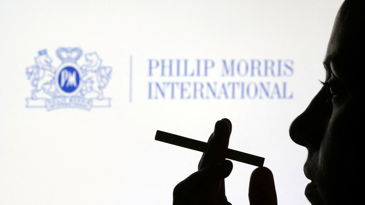 A woman poses with a cigarette in front of Philip Morris International logo in this illustration taken July 26, 2022. REUTERS/Dado Ruvic/Illustration