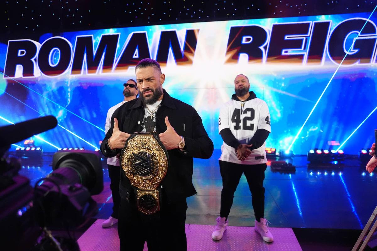  Roman Reigns stands with the World Heavyweight Championship alongside The Usos. Getty Images