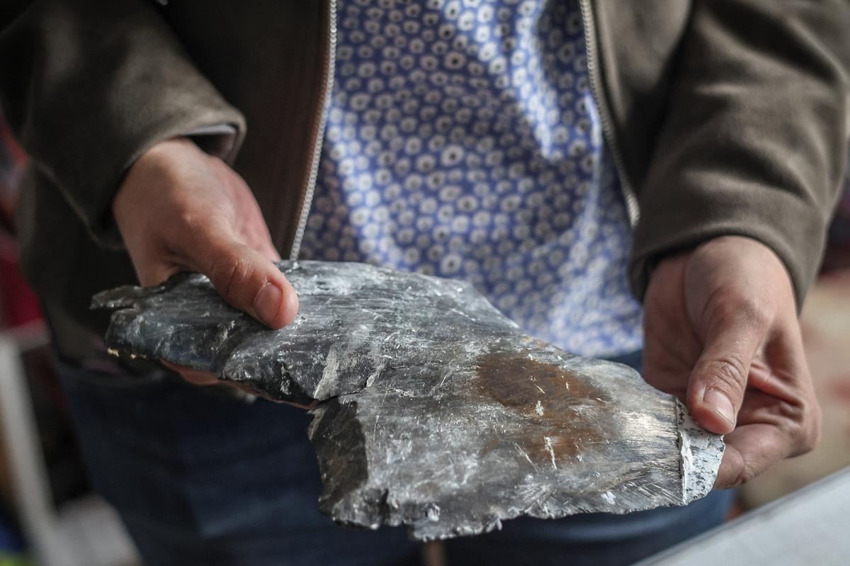 Olha Mudra, 35, a resident who survived yesterday's Russian missile and drone attack,  shows an unidentified metal part, which she found in her apartment soon after the strike happened, amid Russia's attack on Ukraine, in Kyiv, Ukraine, July 3, 2026. REUTERS/Alina Smutko