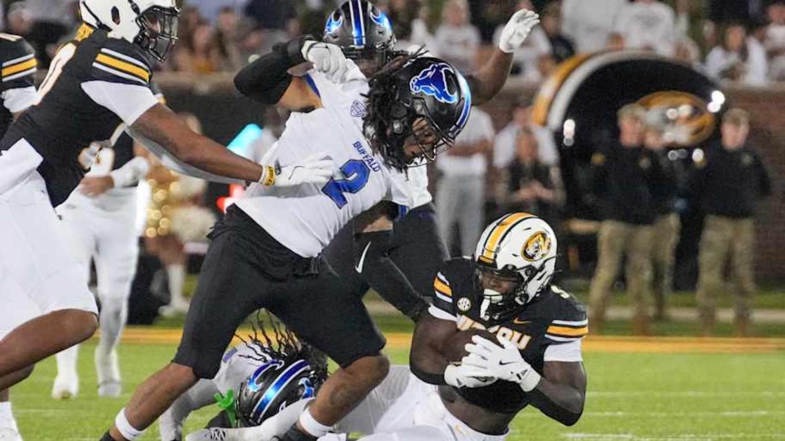  Sep 7, 2024; Columbia, Missouri, USA; Missouri Tigers running back Marcus Carroll (9) runs the ball as Buffalo Bulls linebacker Red Murdock (2) attempts the tackle during the second half at Faurot Field at Memorial Stadium. Mandatory Credit: Denny Medley-Imagn Images | Denny Medley-Imagn Images 