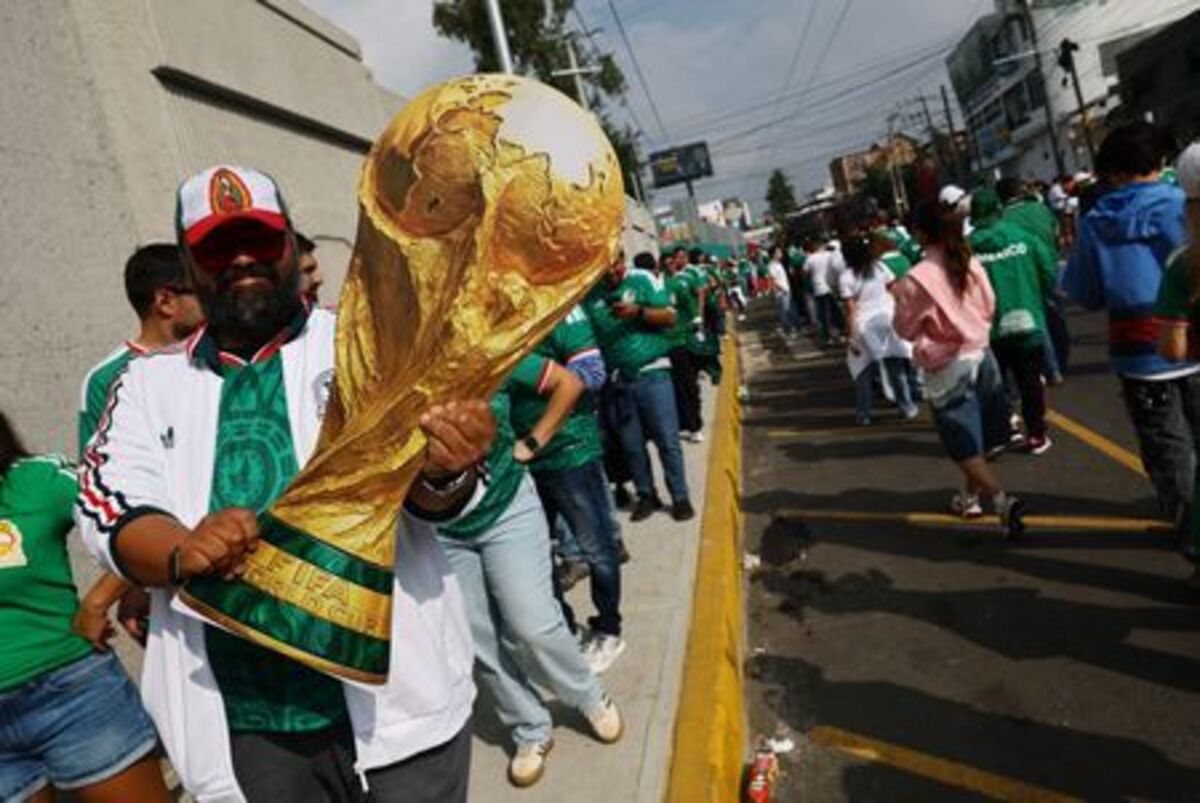 Soccer Football - FIFA World Cup 2026 - Group A - Mexico v South Africa - Estadio Azteca, Mexico City, Mexico - June 11, 2026 A Mexico fan displays a giant replica of the World Cup trophy outside the stadium before the match REUTERS/Kai Pfaffenbach
