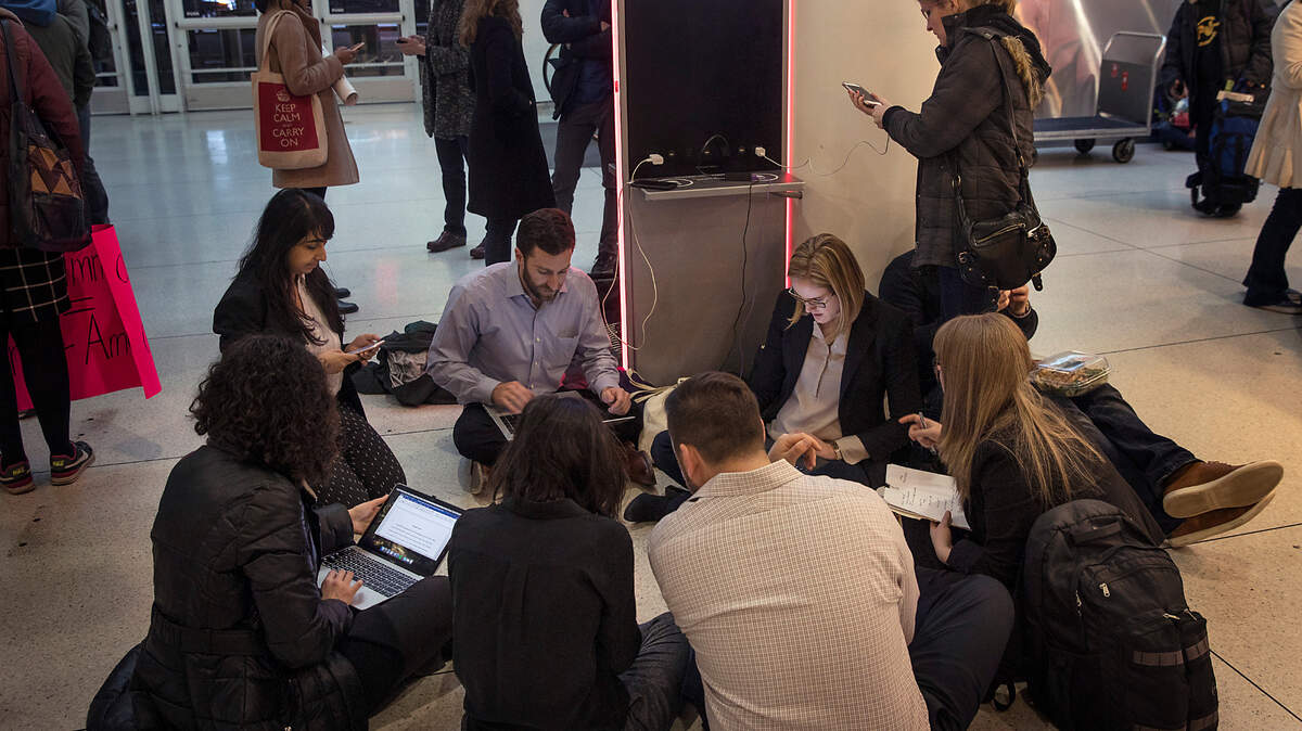 Volunteer lawyers huddle at Kennedy Airport in New York to assist travelers detained in then-President Donald Trump’s executive order barring visitors from seven predominantly Muslim countries in 2017.