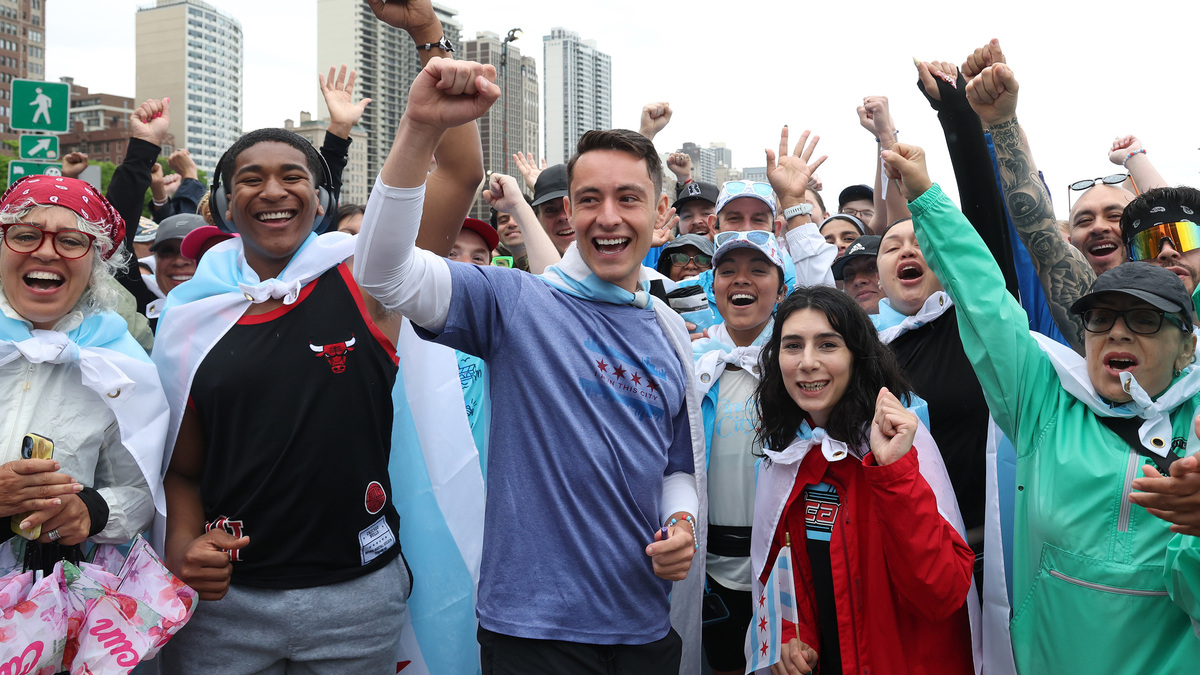 Before the start of their run, Joabe Barbosa rallies the crowd as they prepare to run from Oak Street to Buckingham Fountain in Chicago, Sunday, June 14, 2026. Barbosa completed his mission of running every street in the city and finished with a crowd of people draped in Chicago flags cheering him on. (Antonio Perez/Chicago Tribune/TNS)