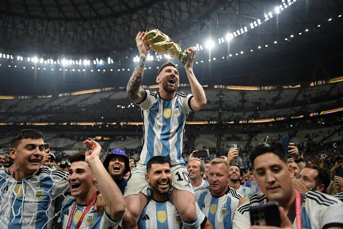  Lionel Messi celebrates with the FIFA World Cup Qatar 2022 Winner's Trophy on Sergio 'Kun' Aguero's shoulders after Argentina's victory against France. Photo by David Ramos - FIFA/FIFA via Getty Images