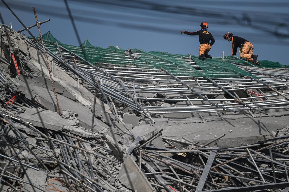 Rescue workers search for trapped survivors among the debris of a collapsed nine-storey building under construction in Balibago, Angeles City, Pampanga, Philippines, May 25, 2026. REUTERS/Noel Celis