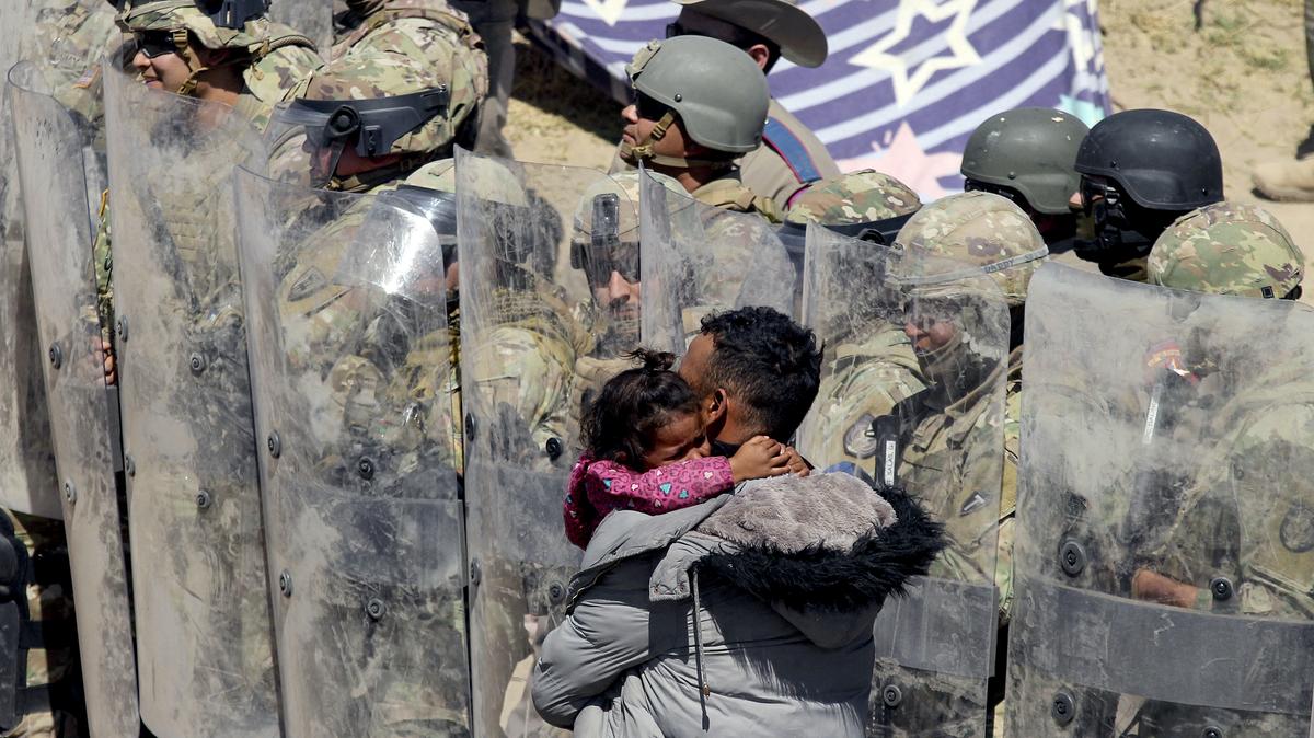 A Venezuelan migrant man carries one of his daughters while being forced to retreat by anti-riot members of the Texas National Guard and highway police who stand guard on the banks of the Rio Grande river to prevent the arrival of migrant people to the US, as seen from Ciudad Juarez, Chihuahua state, Mexico on March 22, 2024. (Herika Martinez/AFP/Getty Images/TNS)
