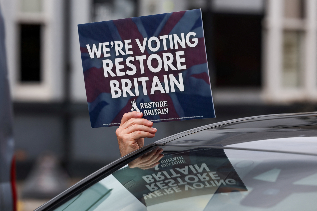 A person holds a campaign placard for the Restore Britain political party during the Makerfield by-election, triggered by the resignation of Labour MP John Simons, in Ashton-in-Makerfield, Britain, June 18, 2026. REUTERS/Temilade Adelaja
