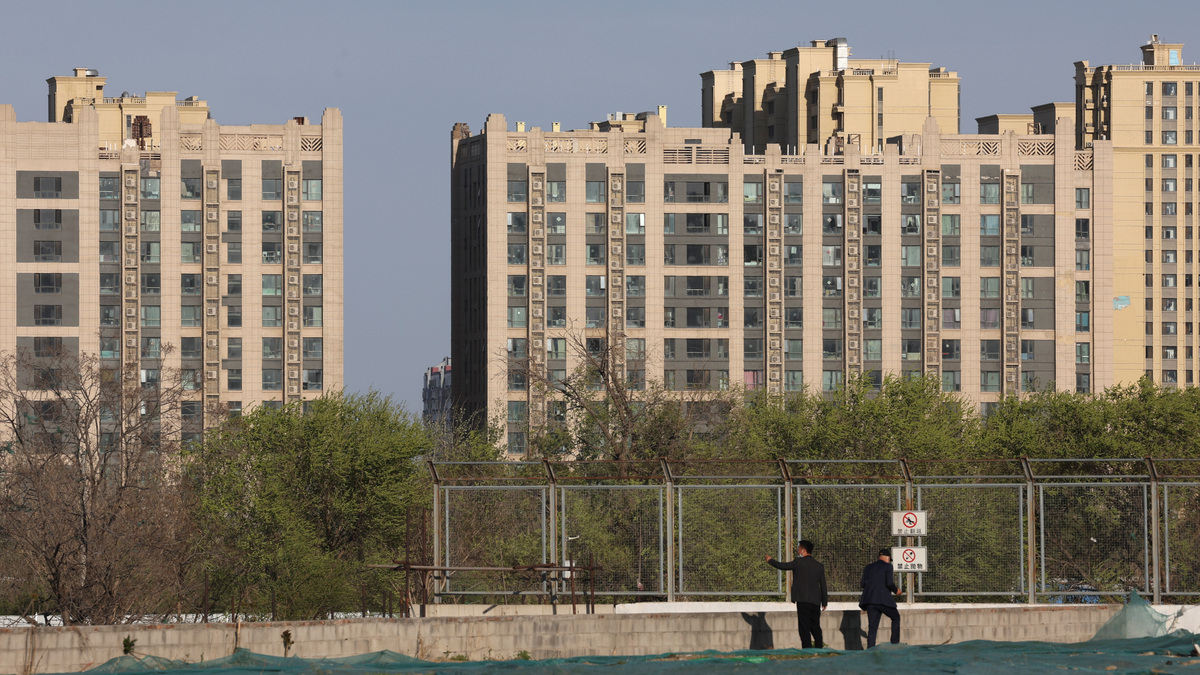 FILE PHOTO: Men stand near residential buildings in Beijing, China April 14, 2022. Picture taken April 14, 2022. REUTERS/Tingshu Wang/File Photo
