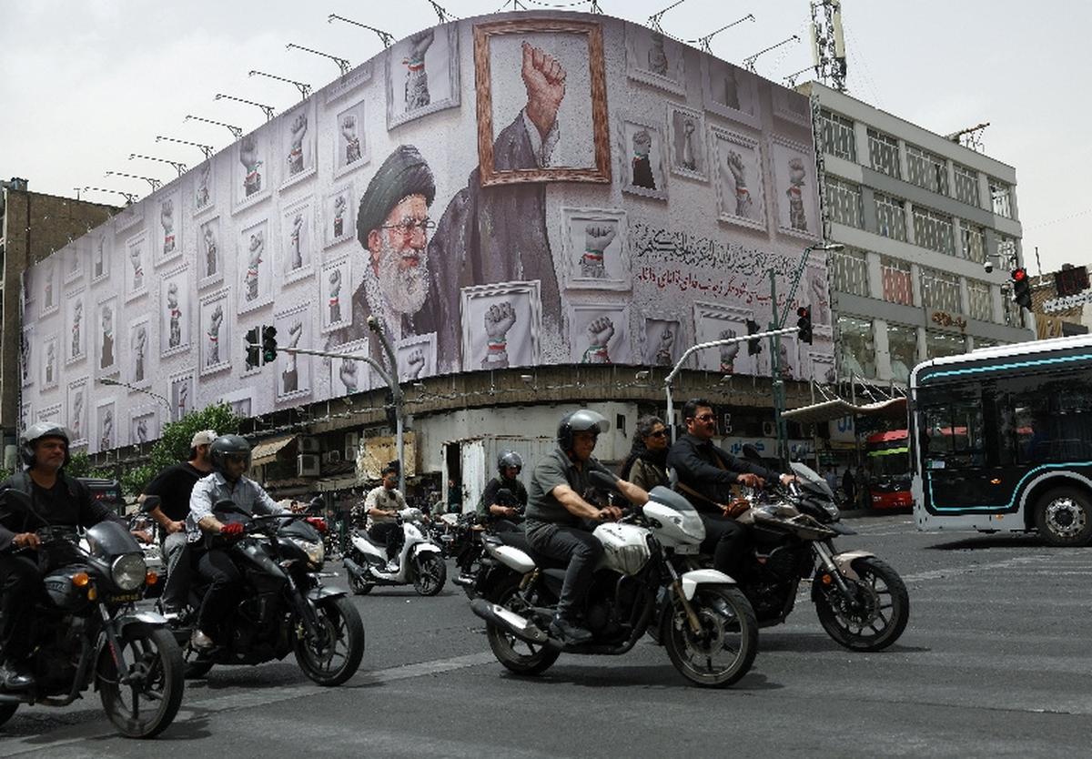 People ride motorcycles near a billboard with an image of the late Iranian Supreme Leader Ayatollah Ali Khamenei, in Tehran, Iran, May 19, 2026. Majid Asgaripour/WANA (West Asia News Agency) via REUTERS