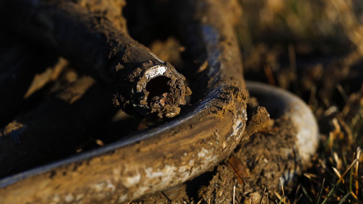 Old lead piping is removed from a home in Galesburg, Illinois, in March 2021. Lead can leach or flake into drinking water from pipes containing lead. (Jose M. Osorio/Chicago Tribune/TNS)