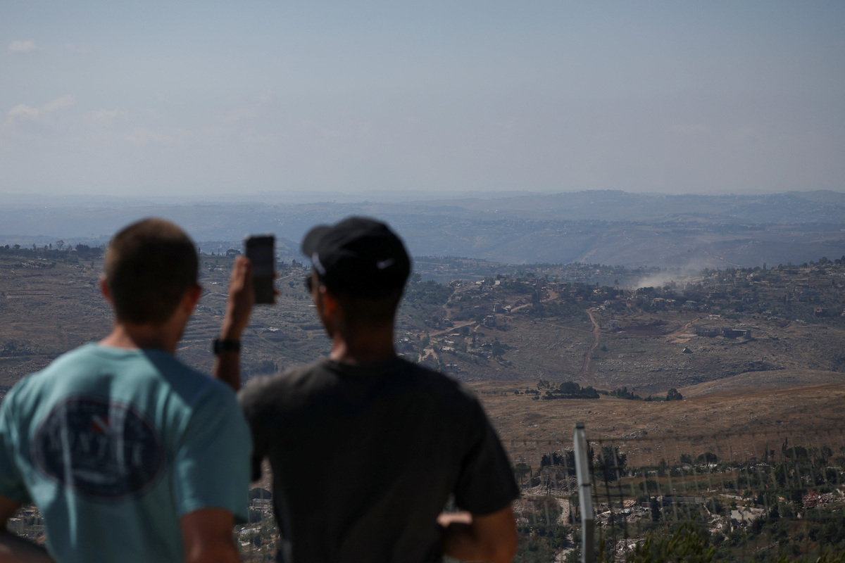 People look at smoke rising in southern Lebanon, as seen from the Israeli side of the Israel-Lebanon border, in northern Israel, June 17, 2026. REUTERS/Shir Torem