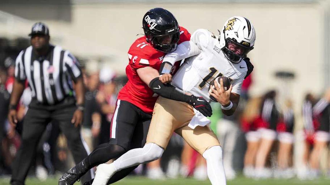  Oct 11, 2025; Cincinnati, Ohio, USA; Cincinnati Bearcats linebacker Jake Golday (11) attempts to tackle UCF Knights quarterback Cam Fancher (14) in the second half at Nippert Stadium. Mandatory Credit: Aaron Doster-Imagn Images | Aaron Doster-Imagn Images 