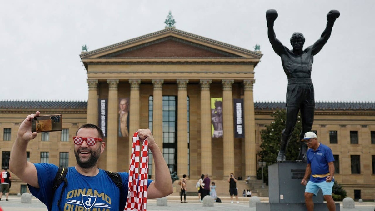  Croatia fan in Philaposes for the World Cup poses for a photo in front of the Rocky Balboa statue (REUTERS/Pilar Olivare)