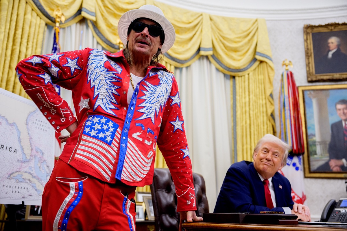 President Donald Trump listens as entertainer Kid Rock speaks during an executive order signing event in the Oval Office of the White House. The country artist is headlining a Turning Point Super Bowl halftime show.